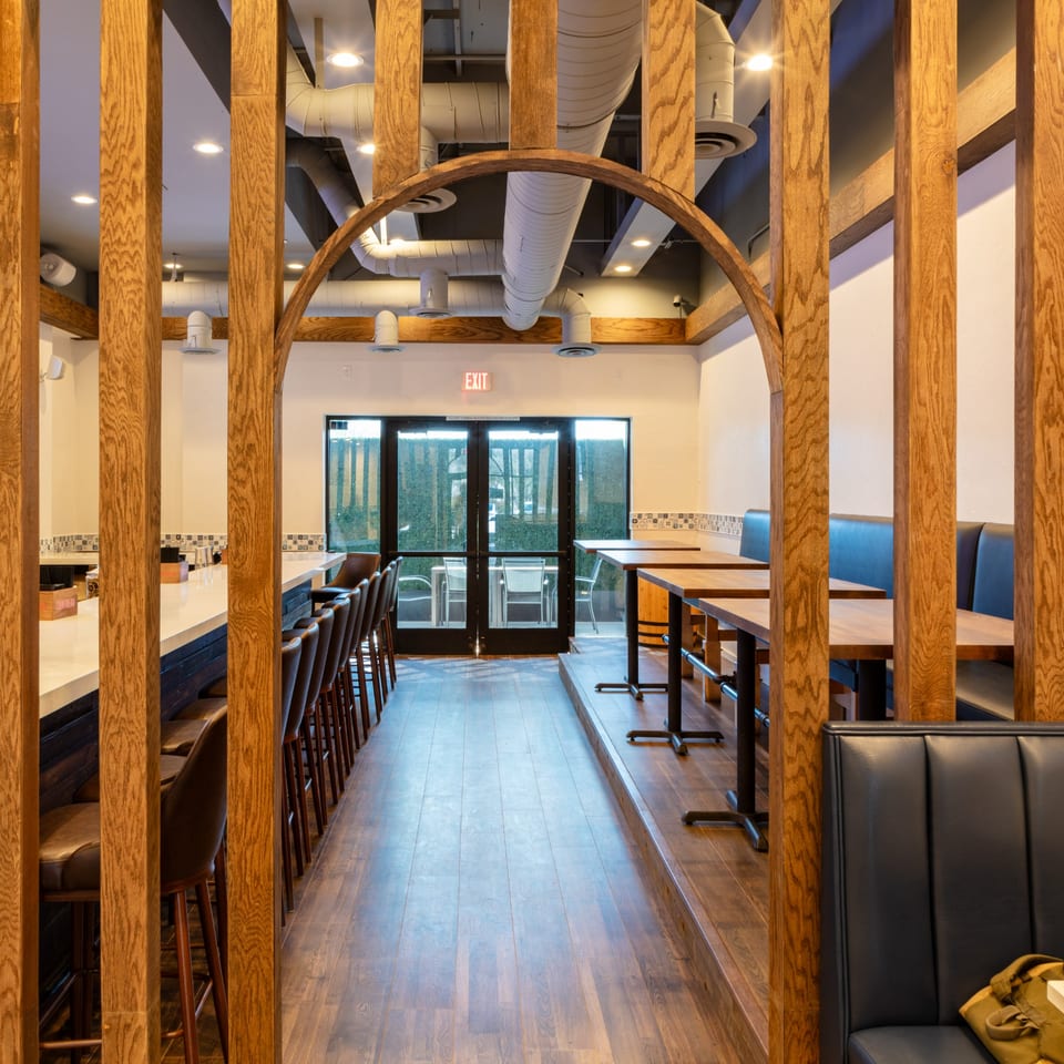 Interior of Wagyu Smashburgers & Tacos, featuring a bar, dining tables, and blue booth seating.